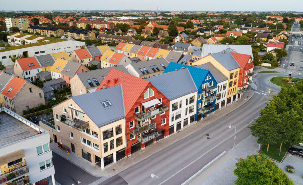 Flygfoto över ett bostadskvarter med flerbostadshus i många olika färger och former.