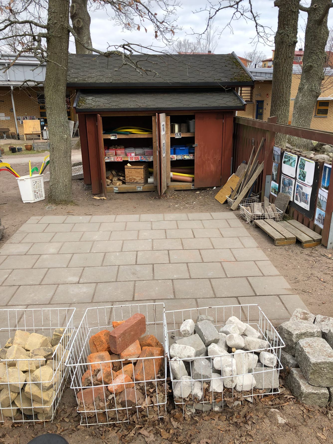 Plattbelagd yta där det finns korgar med olika byggstenar som barnen kan skapa med.