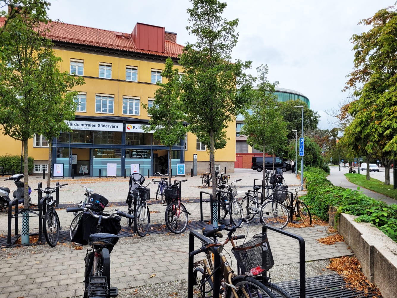Foto på en cykelparkering med en byggnad i bakgrunden.