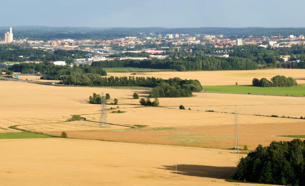 Jordbrukslandskap med stad i bakgrunden. Foto: Mikael Svensson /Johnér bildbyrå