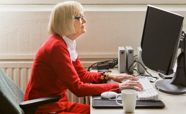 Kvinna vid dator i kontorsmiljö. 