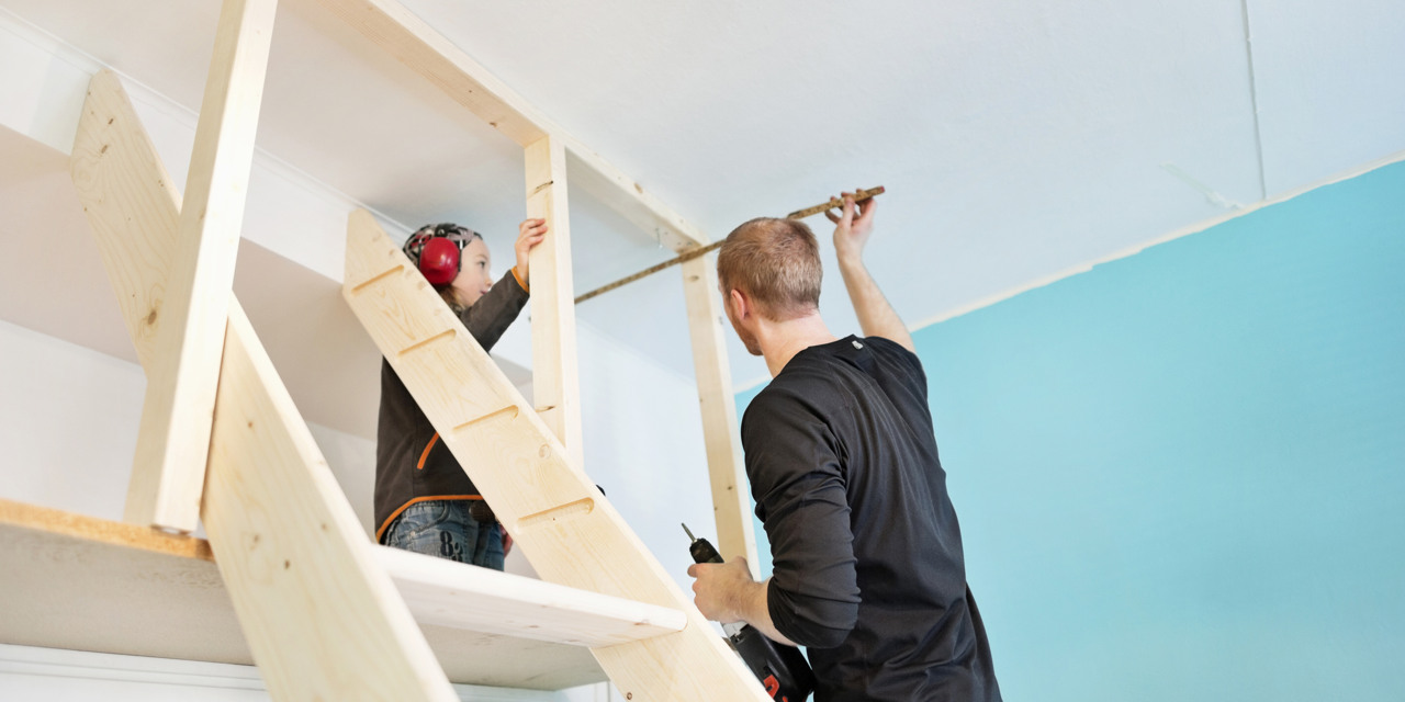 Två personer snickrar inomhus.