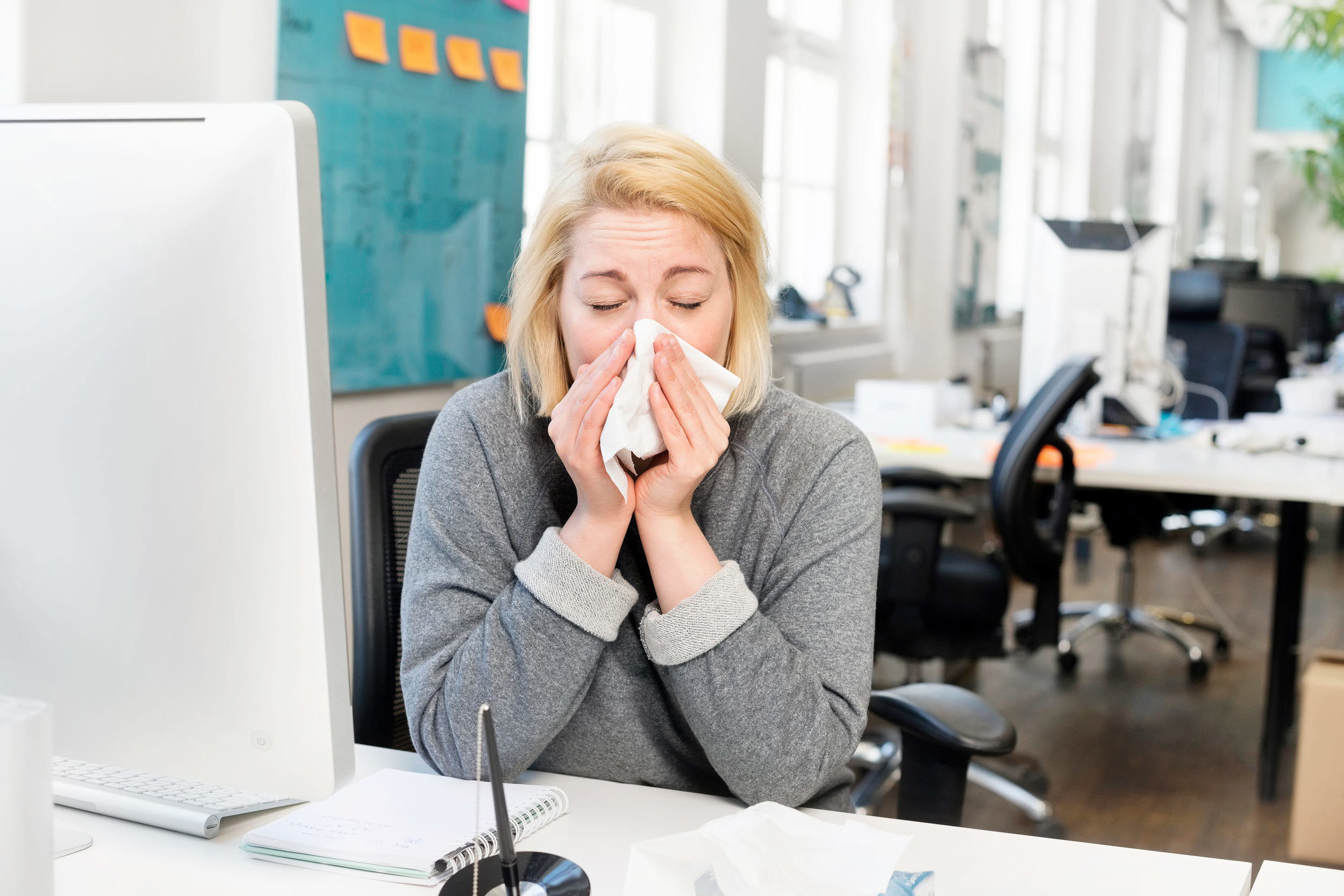 Foto på en kvinna som nyser.