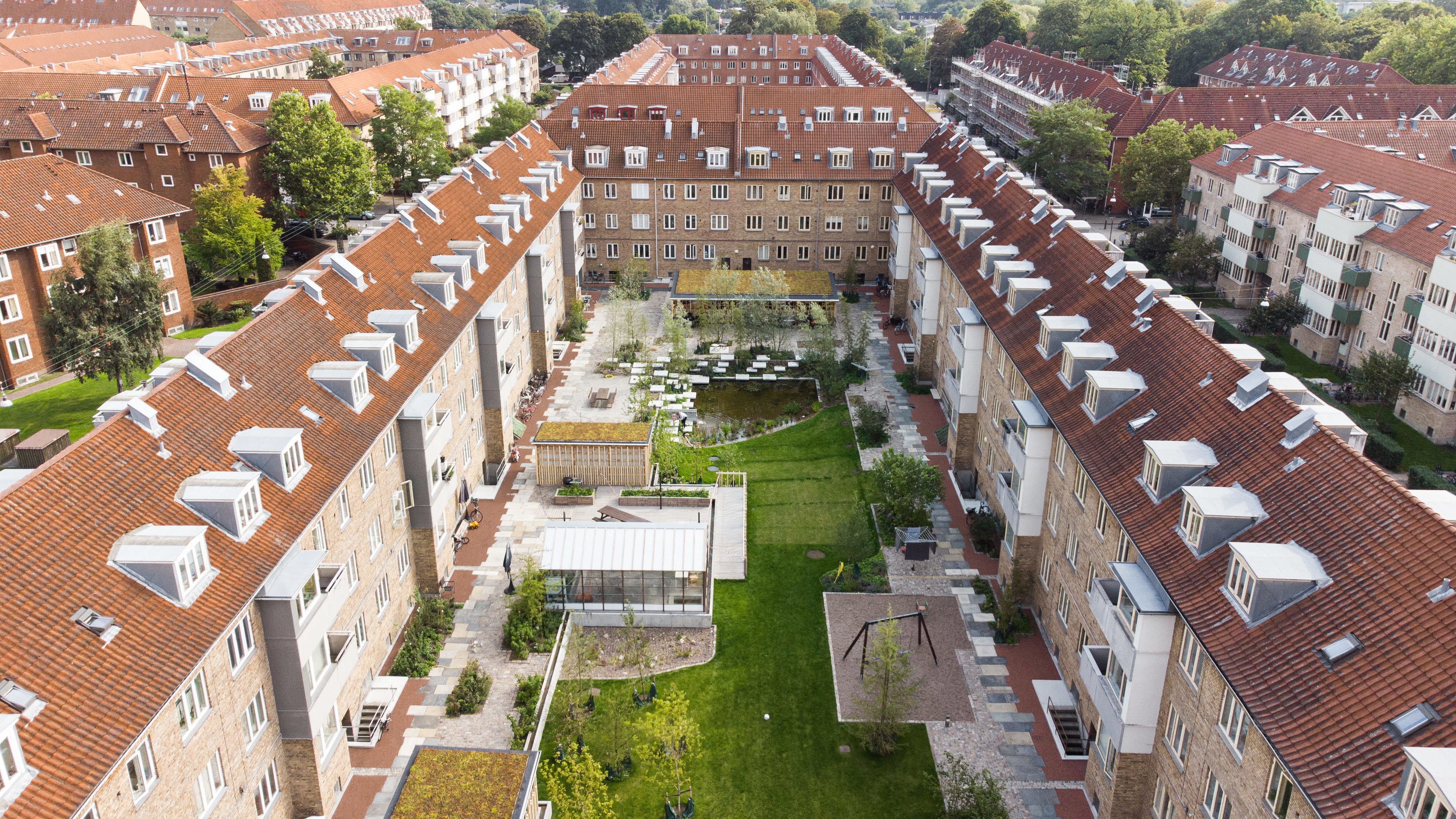 Bostadsgård i ett kvarter med grönska och vatten.
