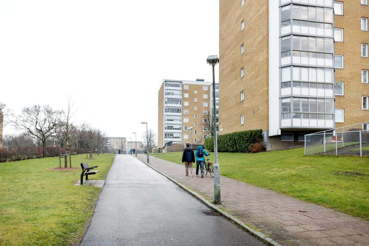 Människor promenerar på trottoar utanför flerbostadshus. Foto: Peter Kroon