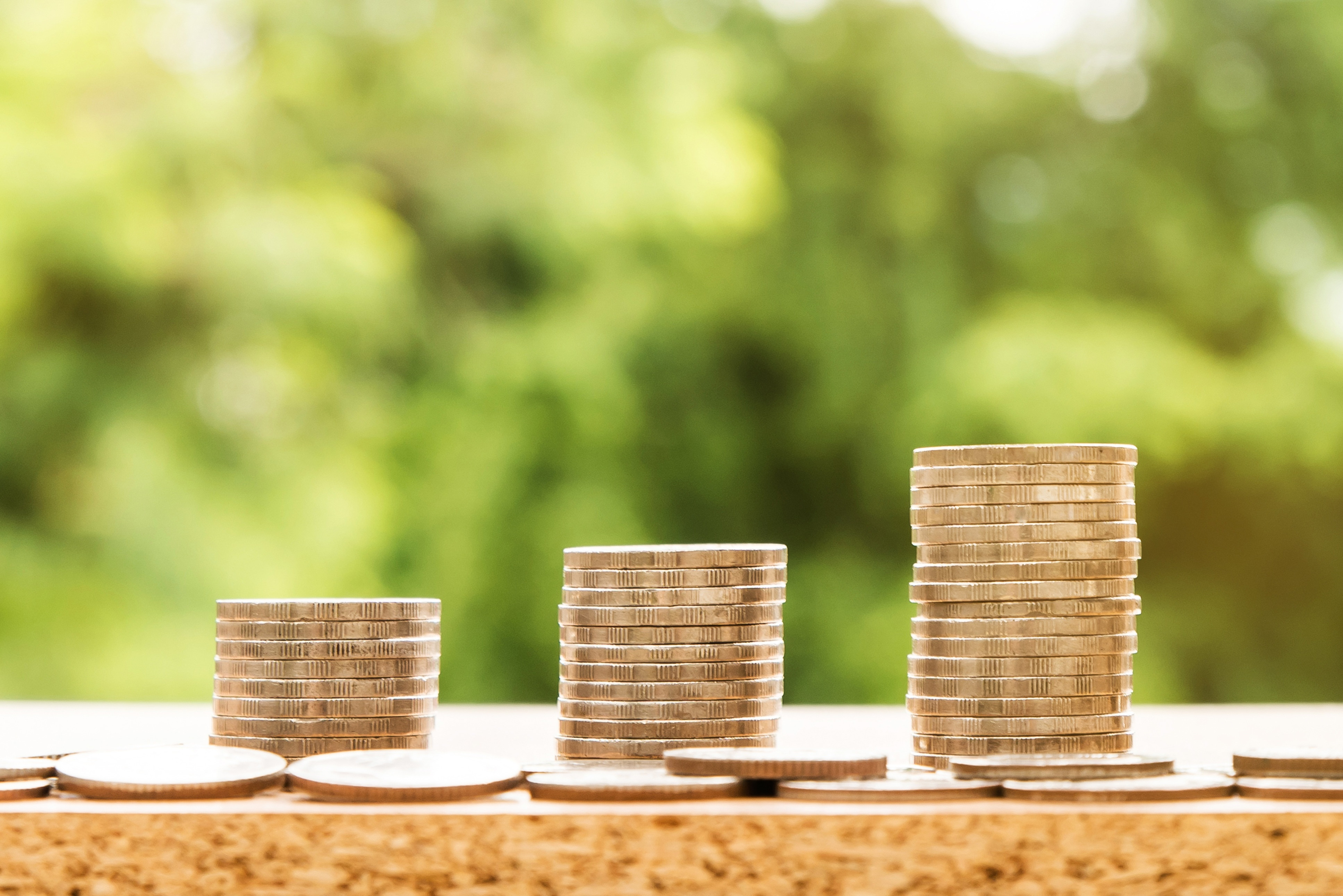 Bild på mynt i tre olika högar på ett bord.