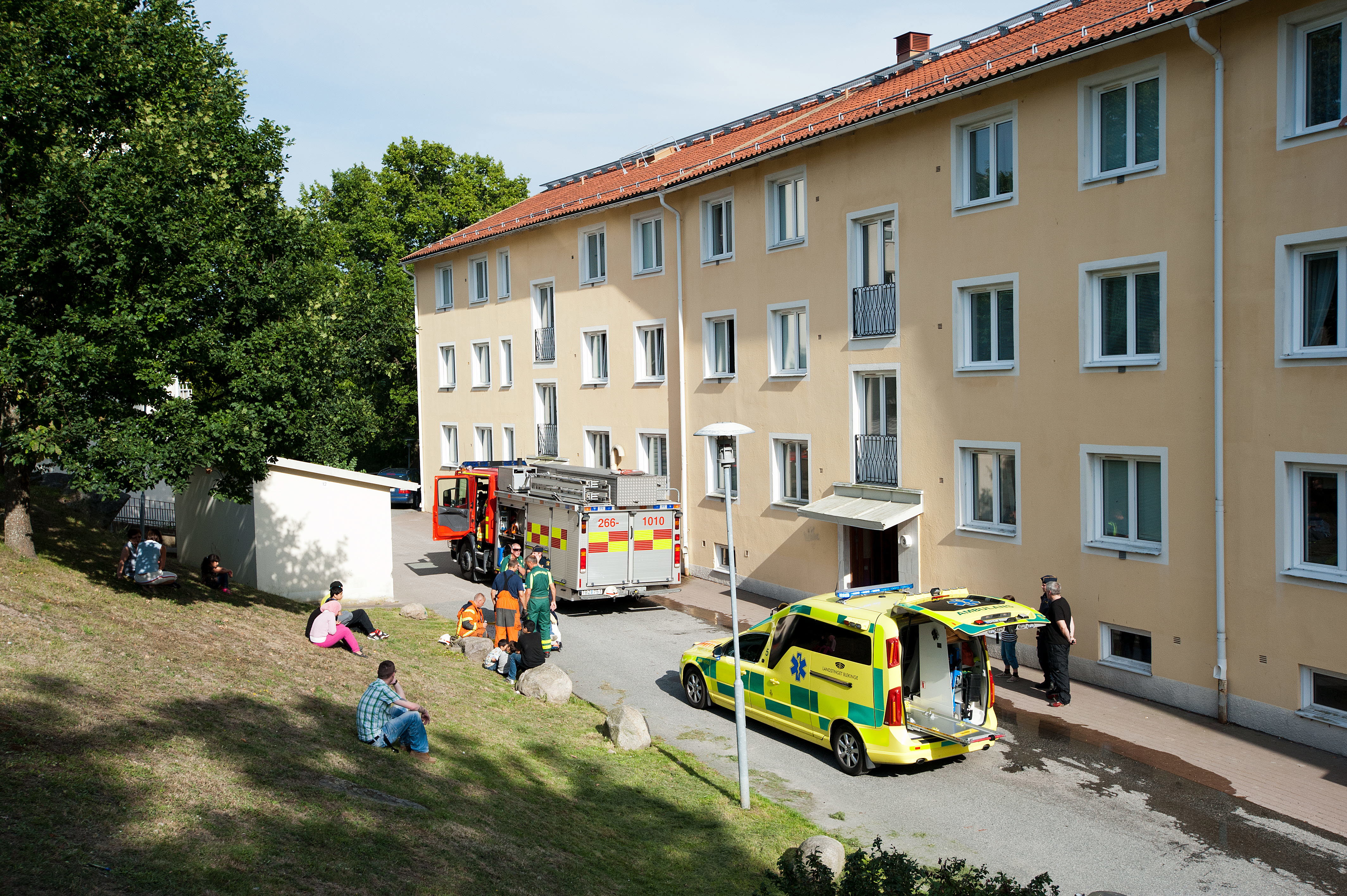 Brandbil och ambulans utanför ett bostadshus.
