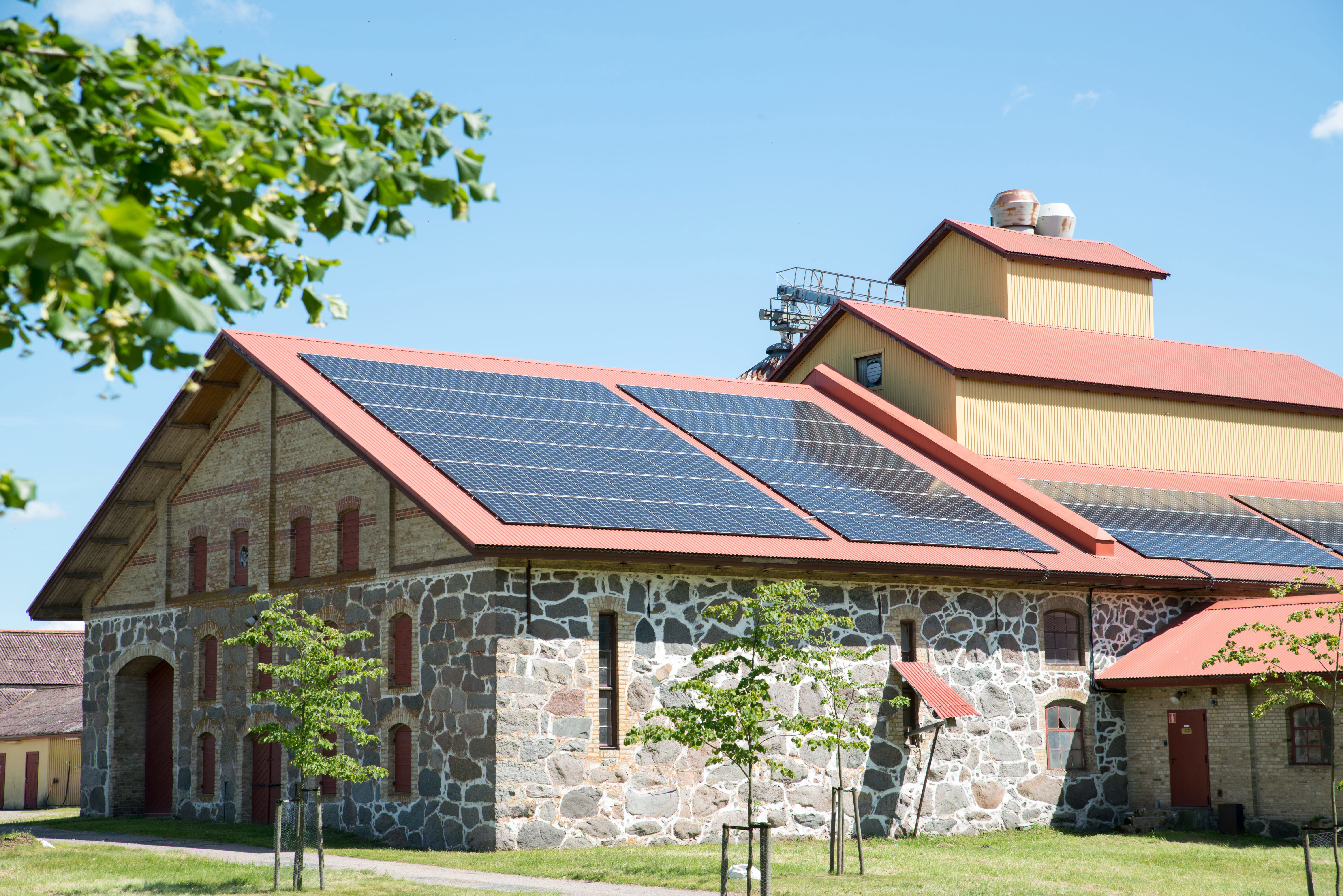 Foto på renoverad gammal lada med solpaneler på taket.