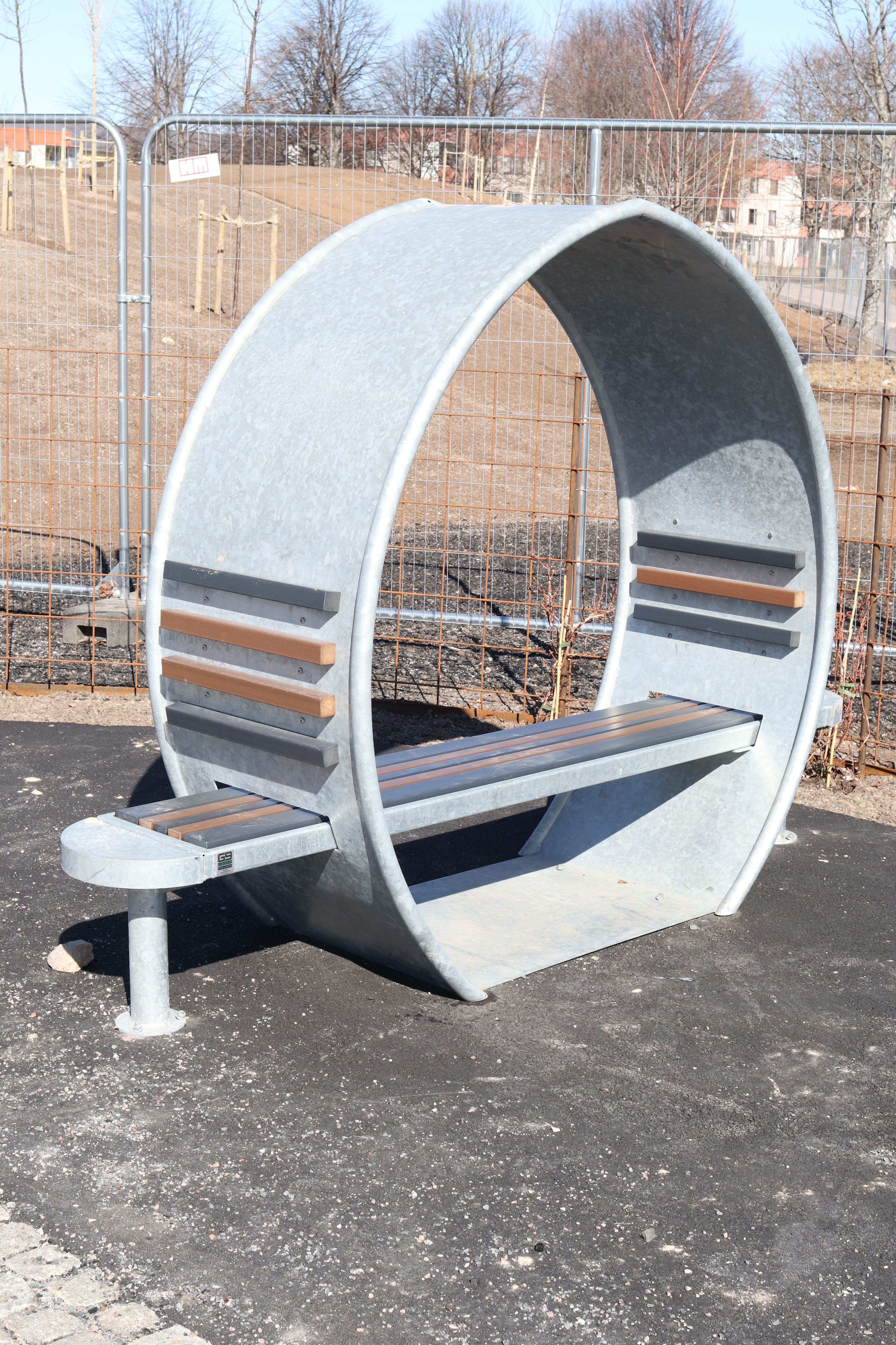 Bilden visar en parkbänk i form av en cirkel. Parkbänkarna i bostadsområdet har samskapats av tjejer i området.