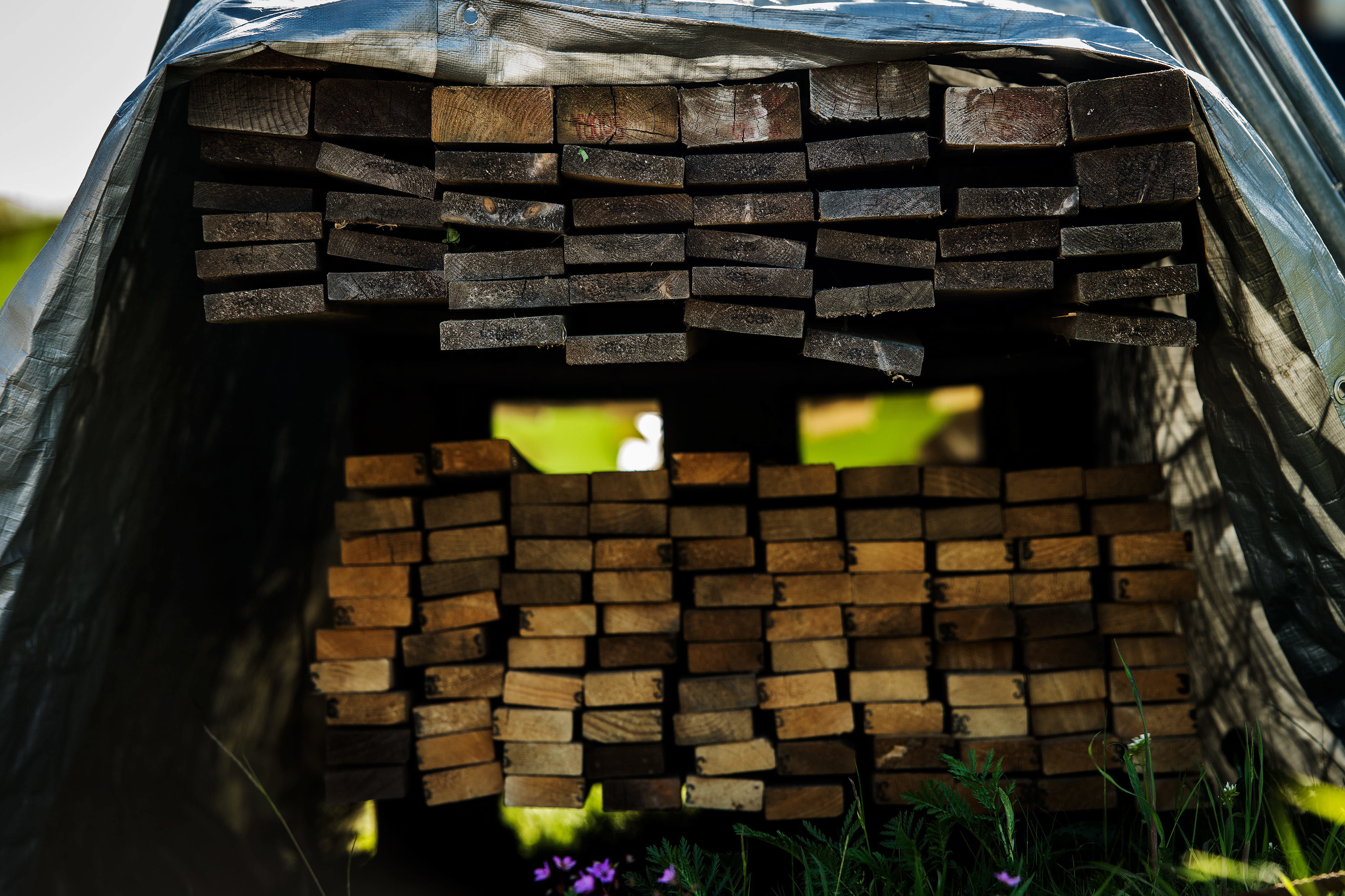 Bild på blöta plankor som är övertäckta med en presenning.