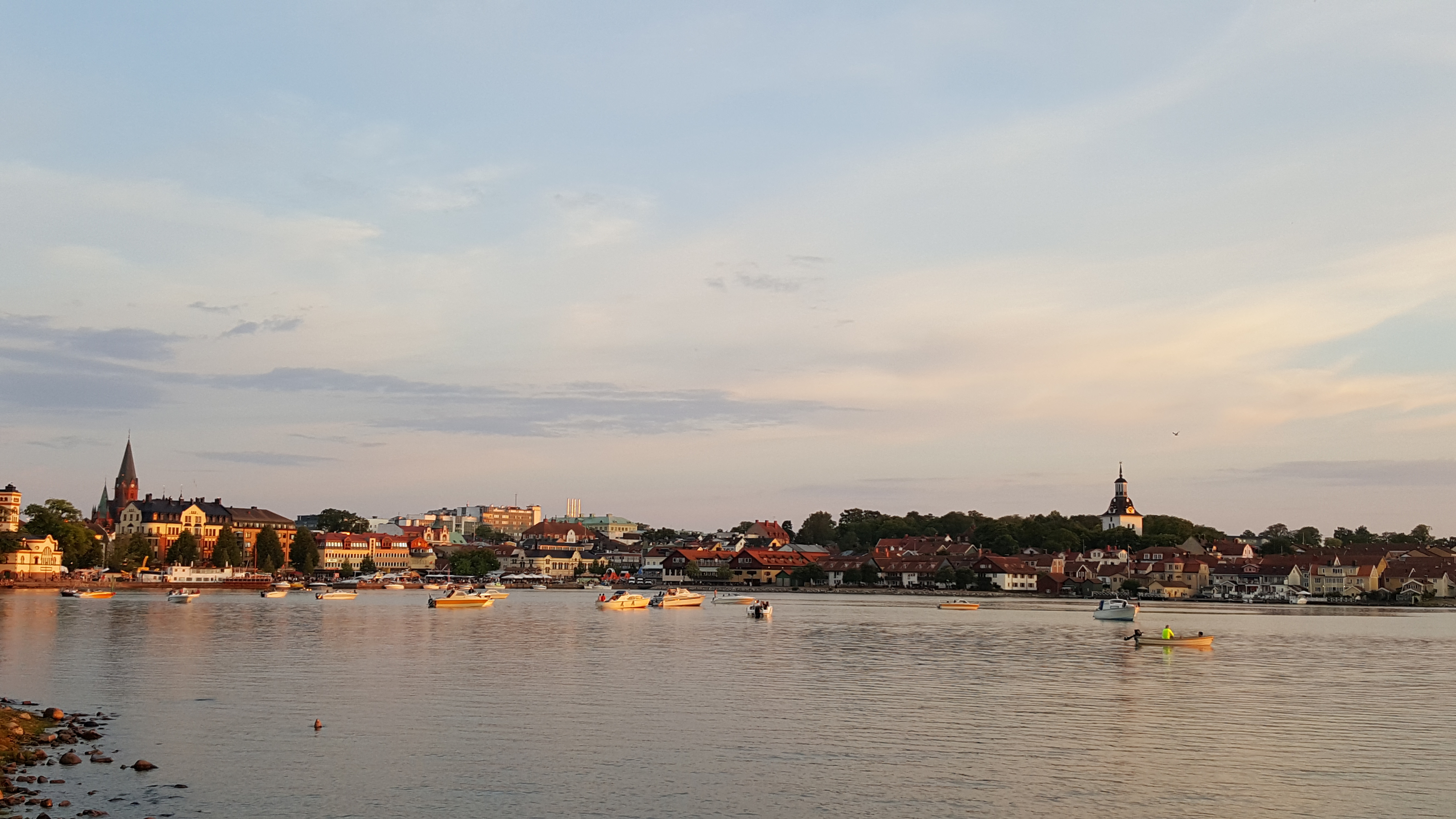 Fot med Västervik stadd med vatten, båtar och solnedgång