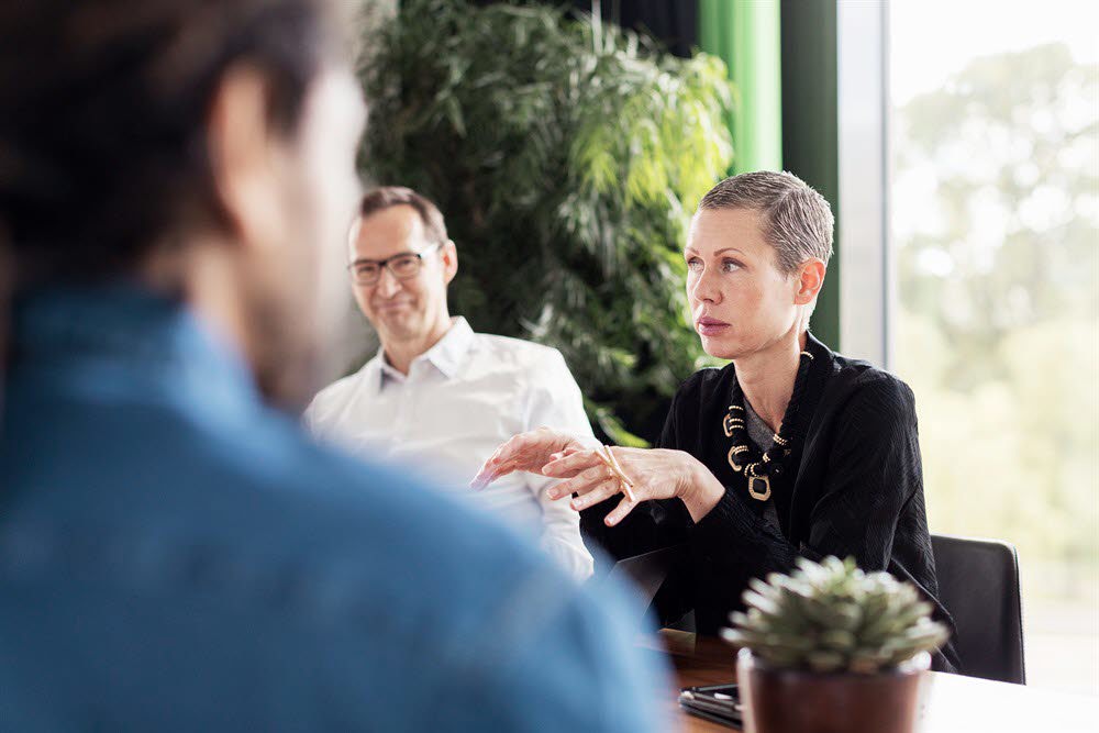 Tre personer i möte sittande vid ett bord. Foto: Johnér.