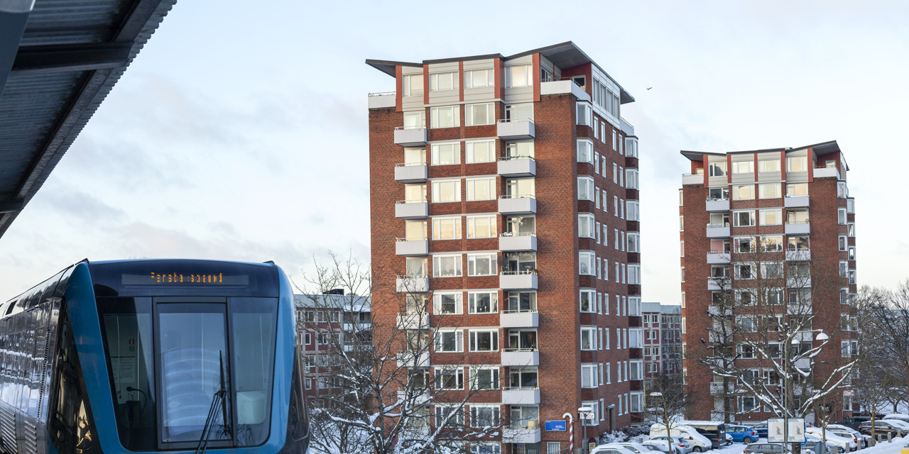 Tunnelbana passerar ett bostadsområde med två höghus.