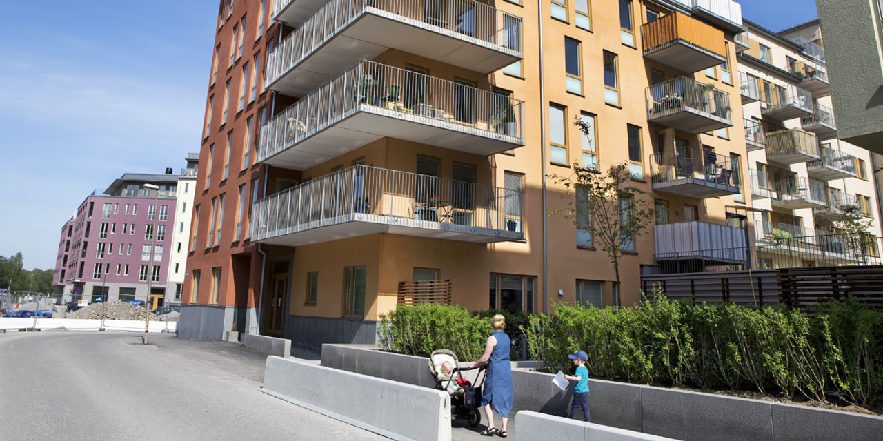 Människor på väg mot ett flerbostadshus