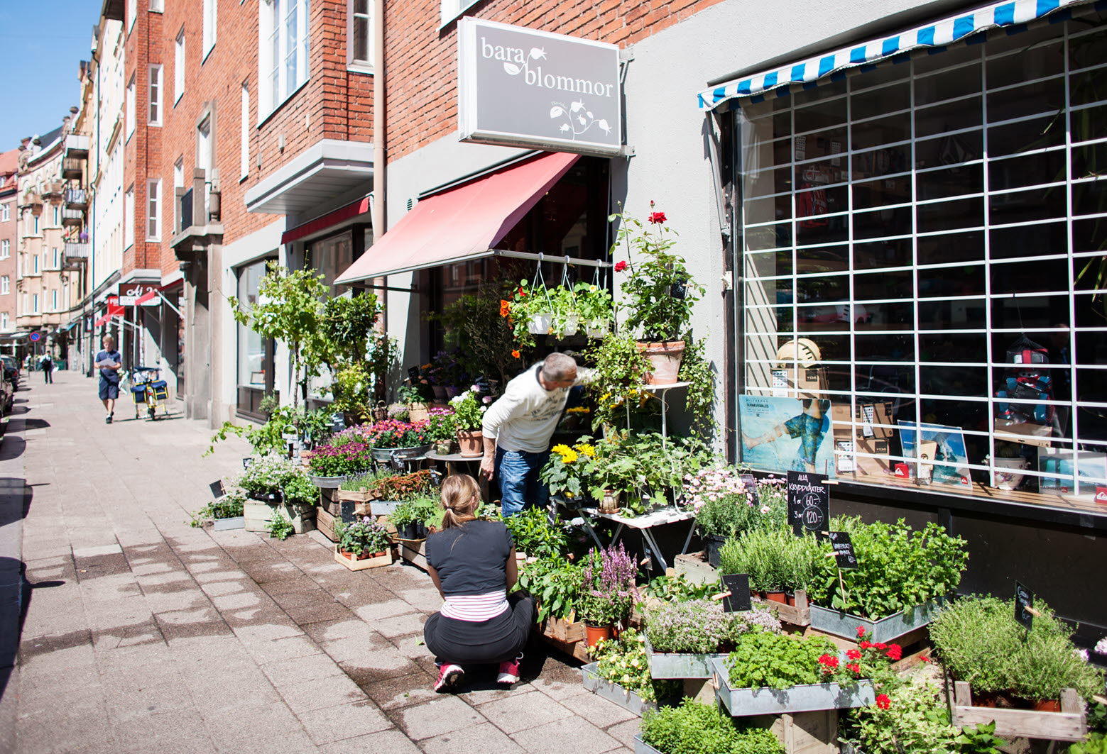 Människor utanför blomsteraffär i Malmö. Foto: Peter Kroon