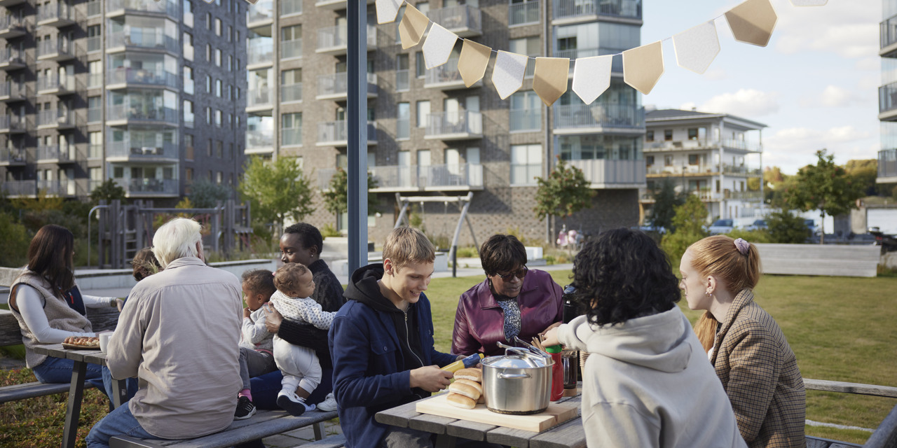 En grupp människor som sitter ute vid ett picknickbord.