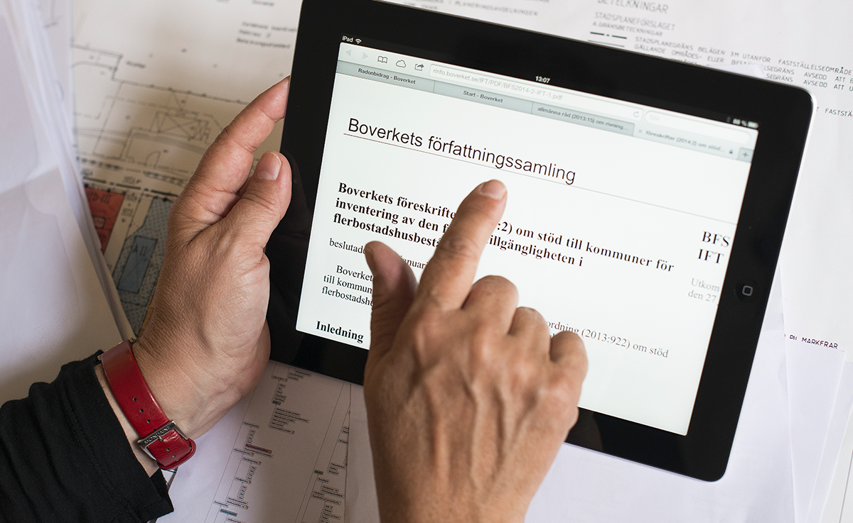 En hand pekar på en surfplatta.