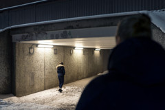 Silhuett av en man som tittar på en tjej i en gångtunnel.