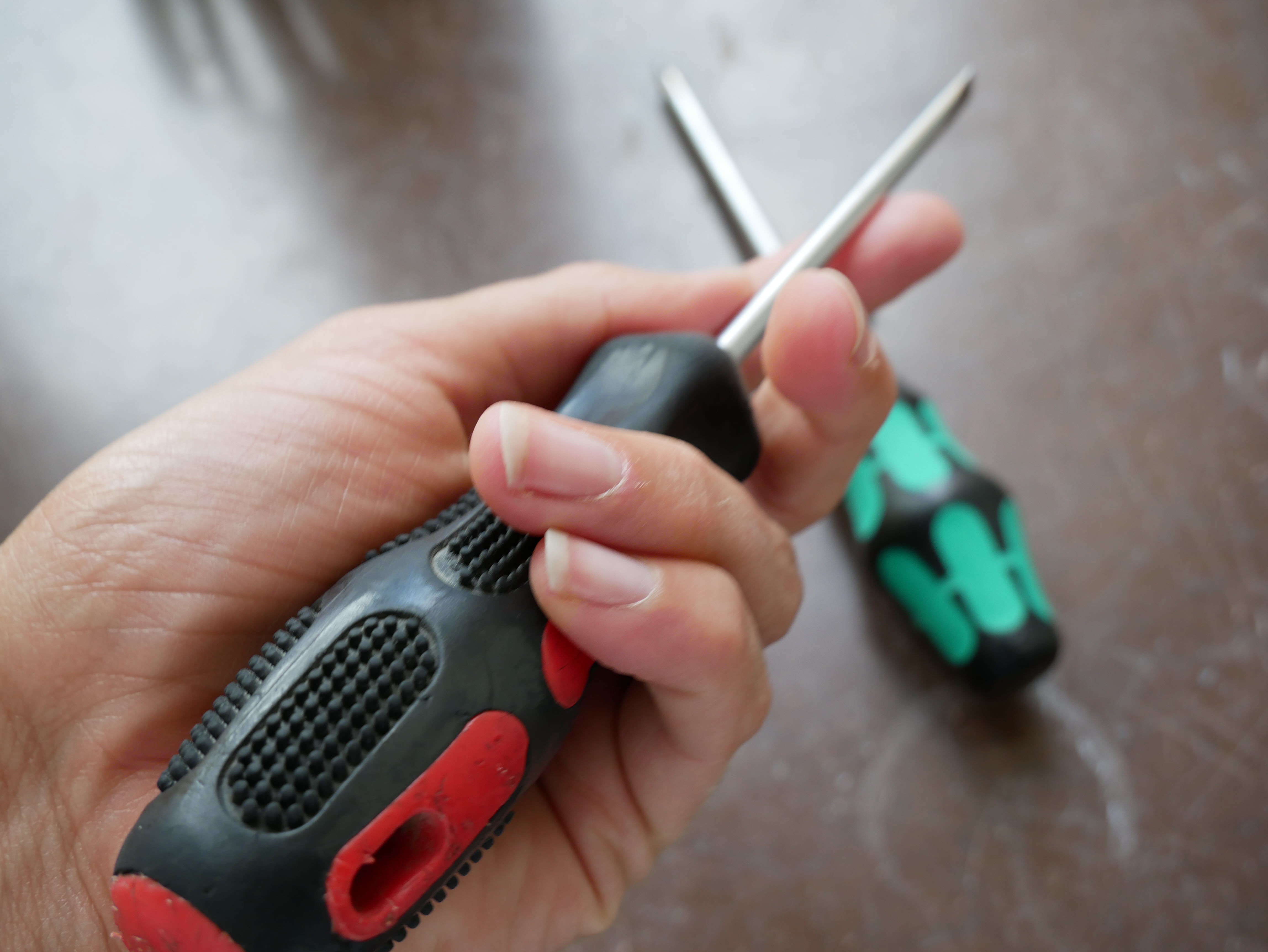 Hand med skruvmejsel.