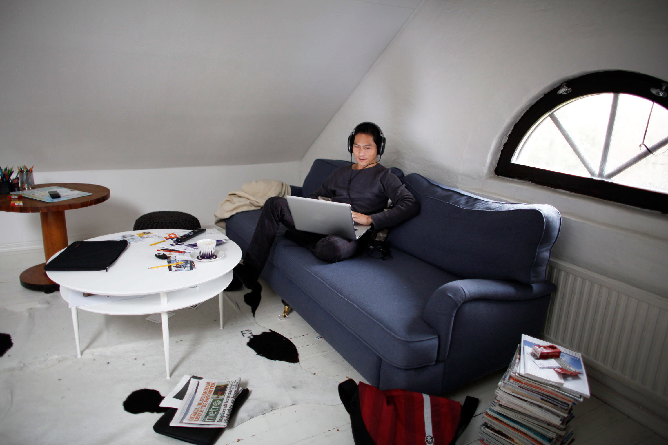 Person som sitter i soffa i hemmiljö med bärbar dator i knät