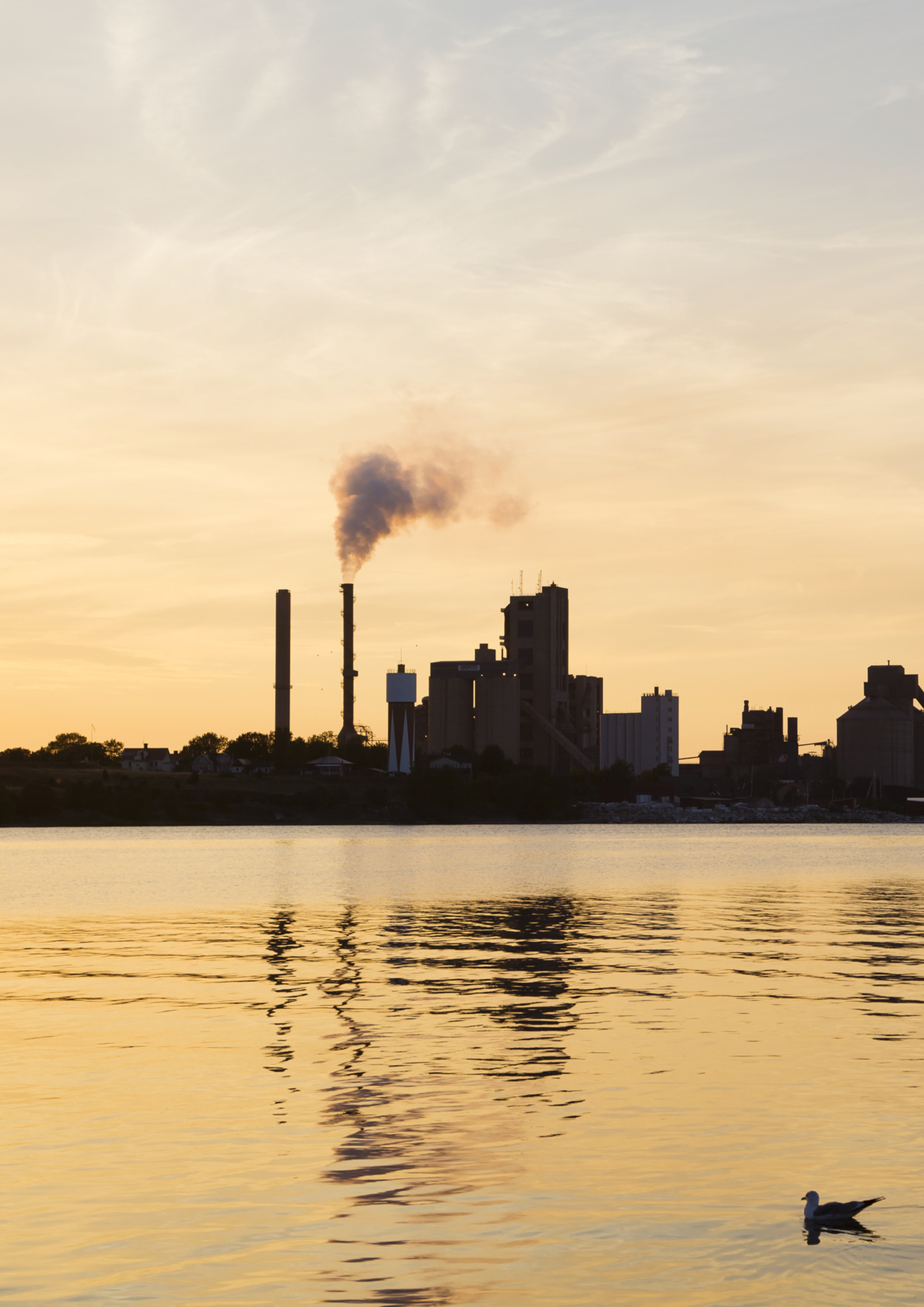 Vatten med en fabrik i bakgrunden.