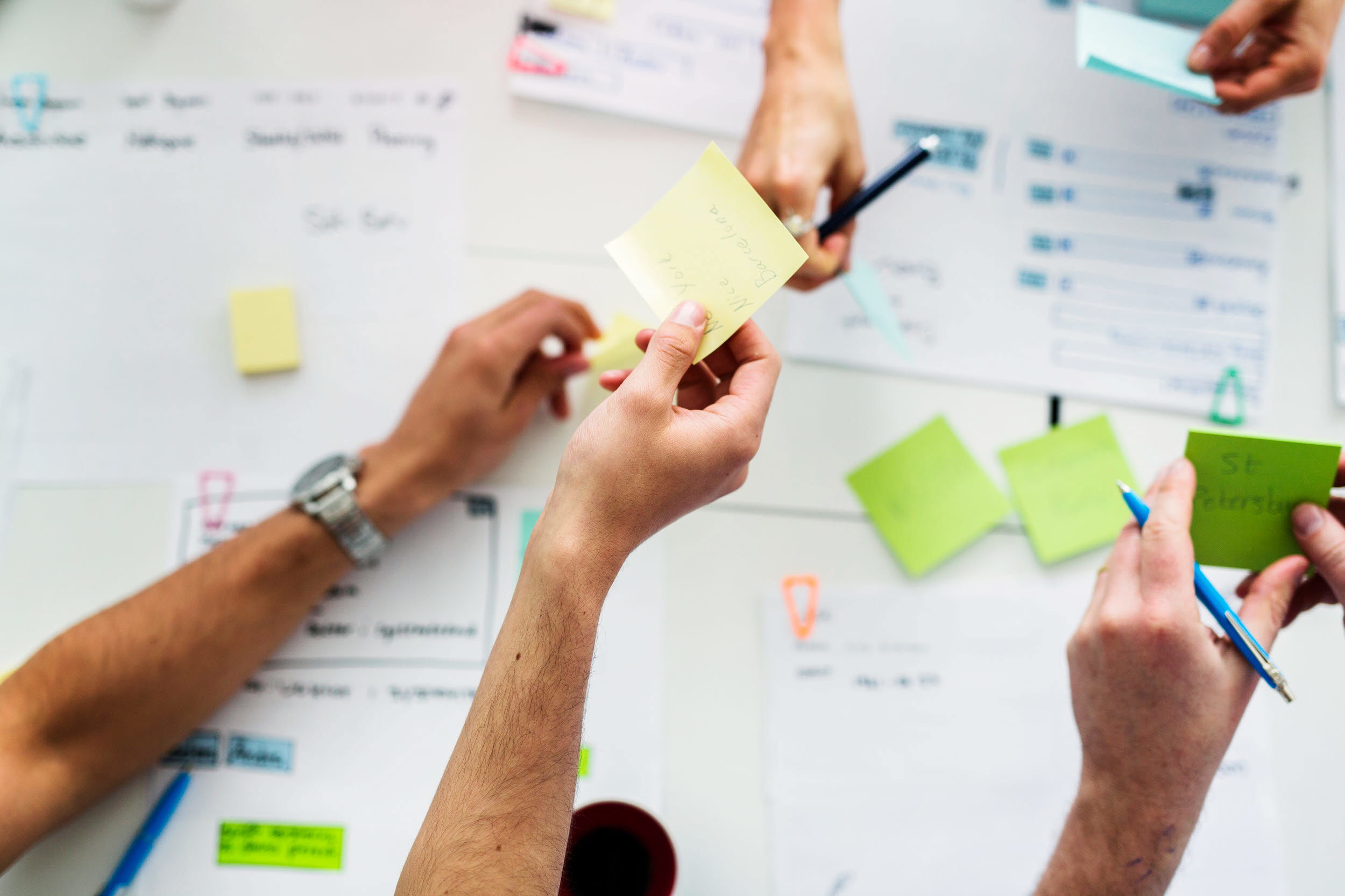 Foto på händer som arbetar med planer.
