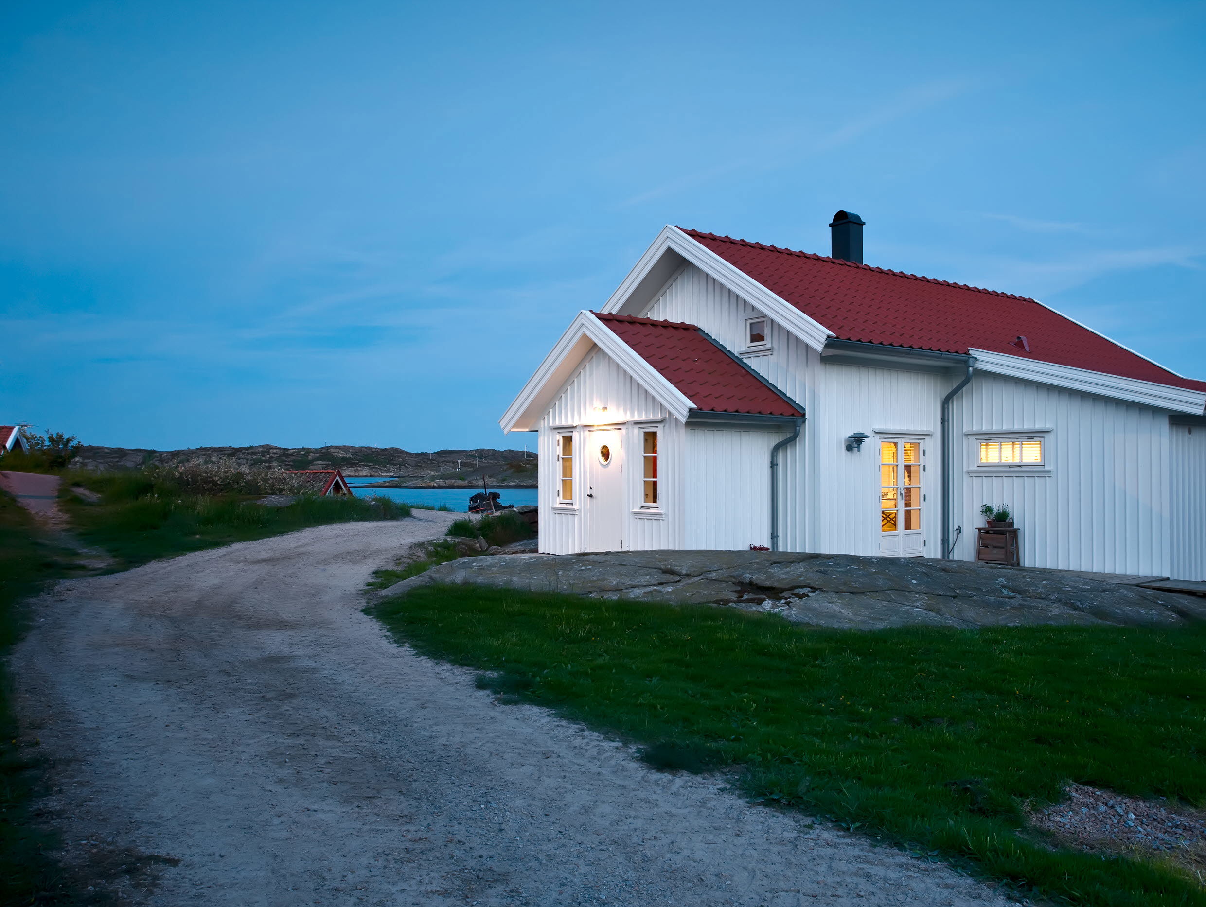 Ett vitt hus vid en landsväg i skymningen. Foto: Stefan Isaksson/Johnér Bildbyrå