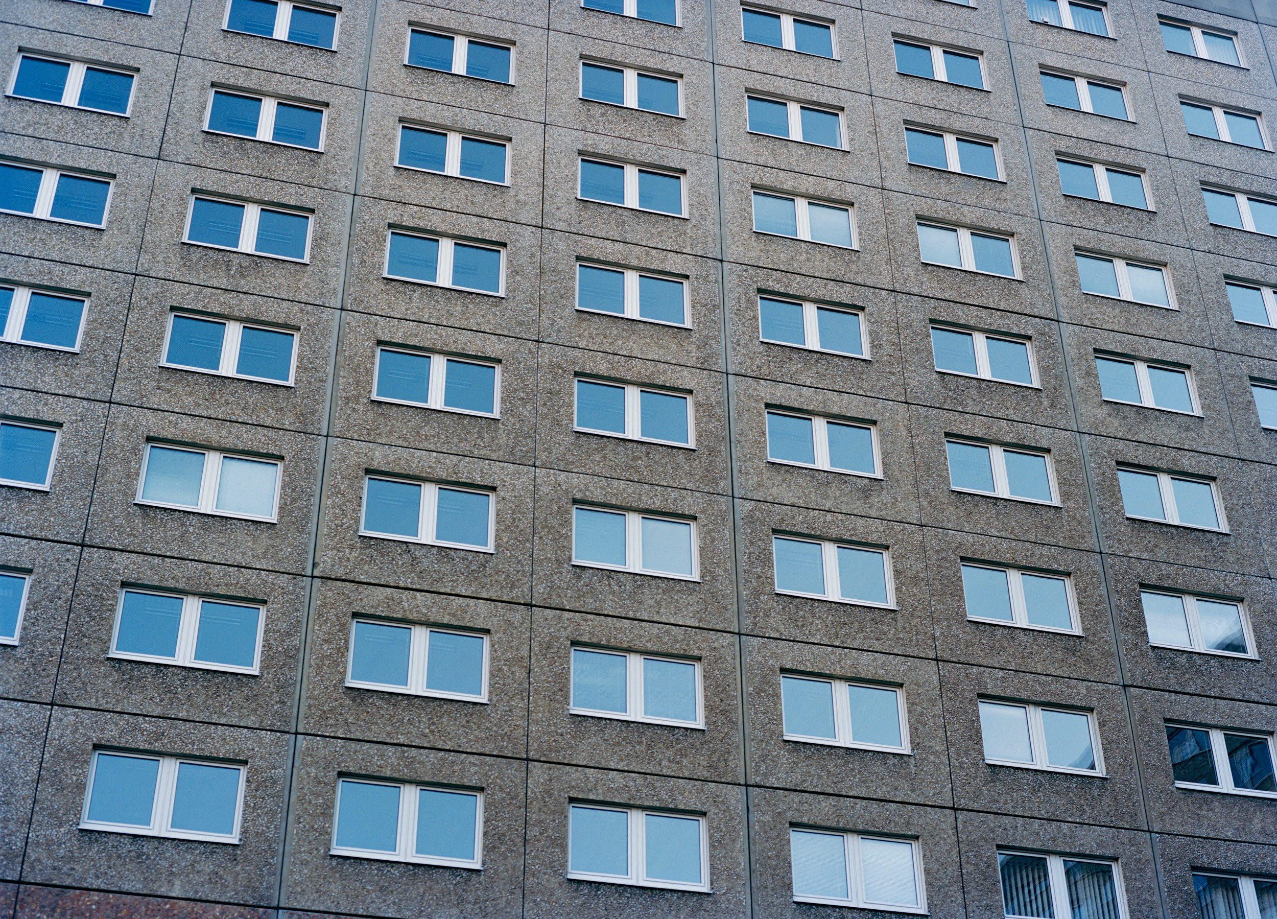 Bild på en flerbostadbyggnads fasad med fönster.