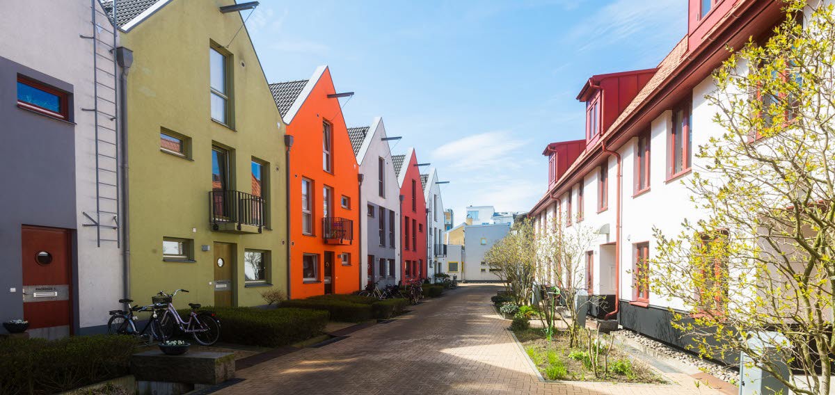 Flerbostadshus i olika färger på gata.
