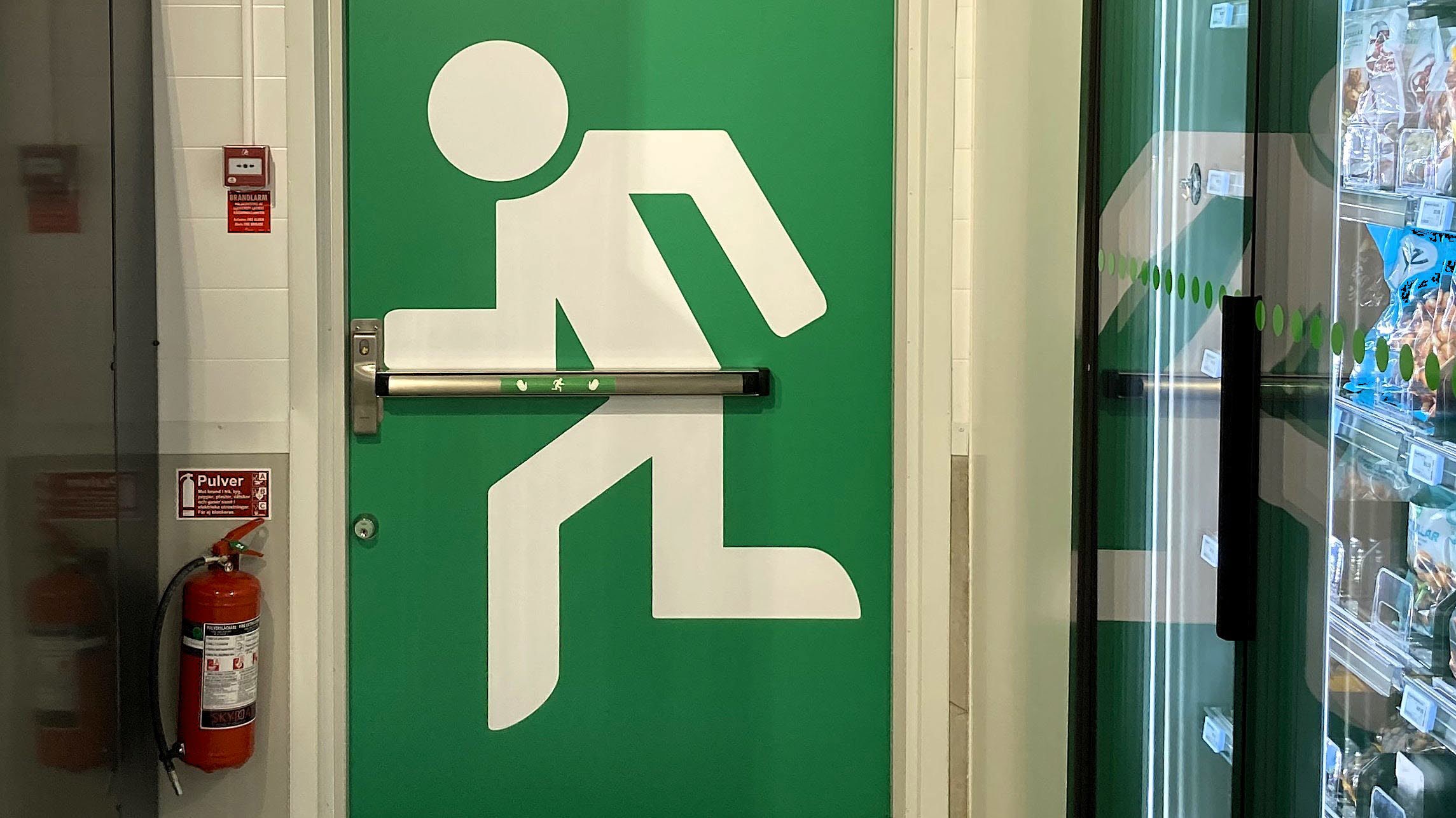 Branddörr med en stor målad bild med utrymningssymbol på.