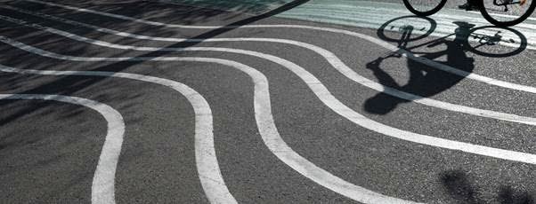 Foto av en cykelväg med ränder och en cyklist