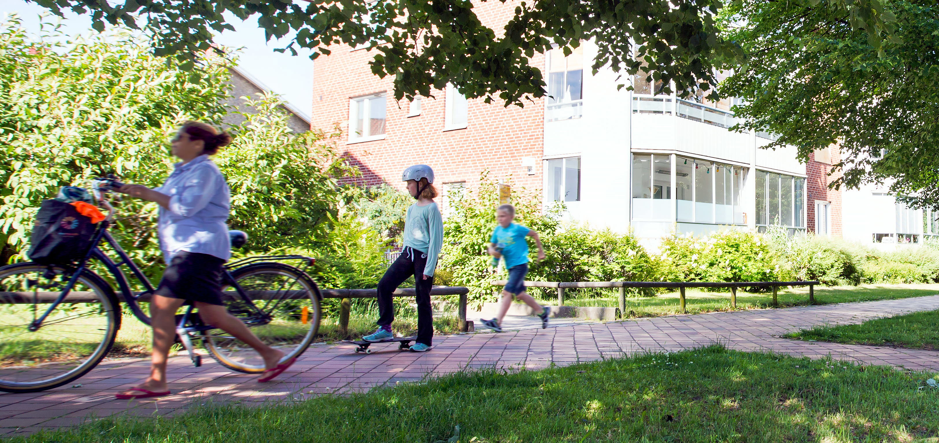 Grönskade gång och cykelbana i stadsmiljö.