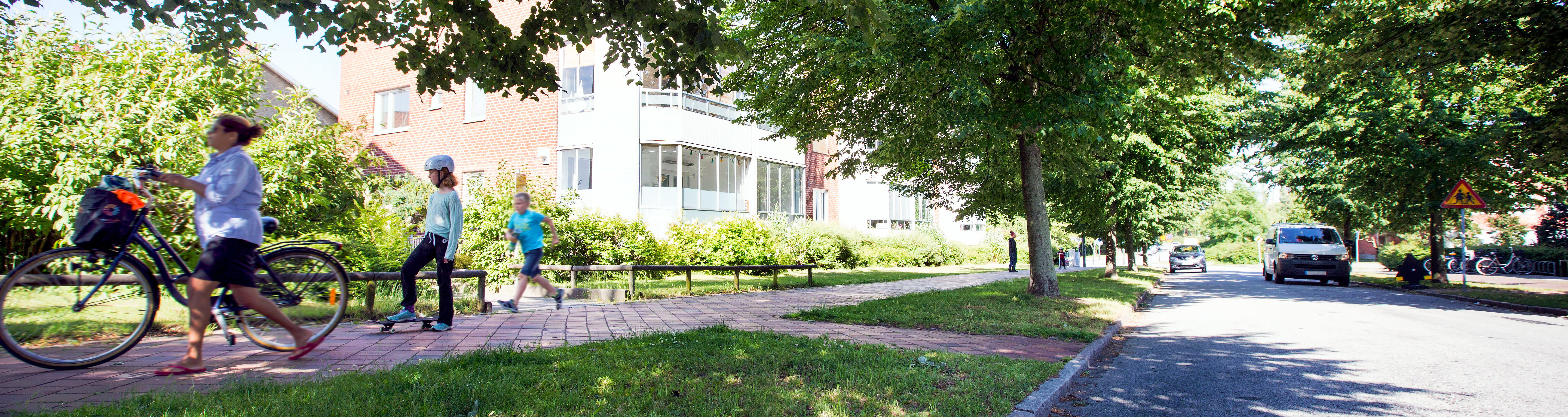 Grönskade gång och cykelbana i stadsmiljö.