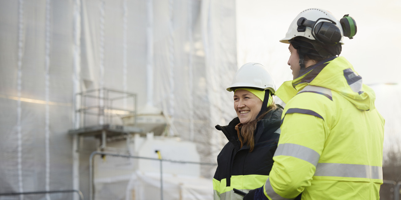Fyra personer med varseljackor och bygghjälm kontrollerar en byggarbetsplats. Foto: Franz Feldmanis