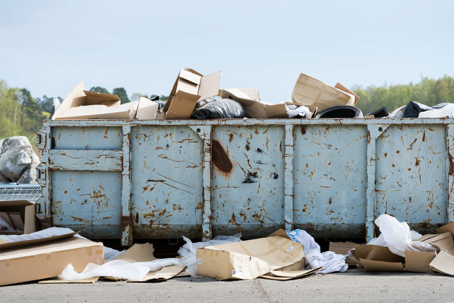 Sopcontainers med skräp i och utanför.