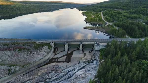 Dammanläggning i ett stort vattendrag med skog längsmed sidorna