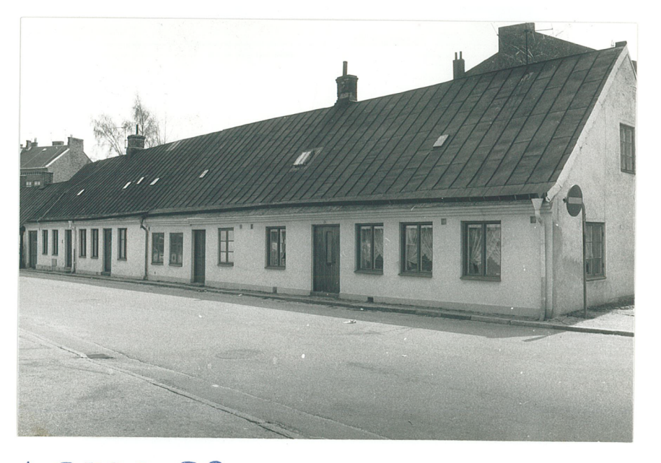 Äldre envåningslängor längsmed gata_svartvitt foto