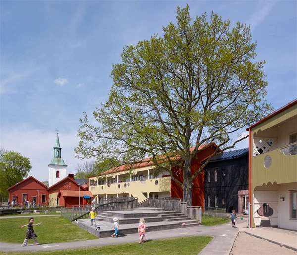 Barn som går på olika gångvägar framför skolans byggnader.