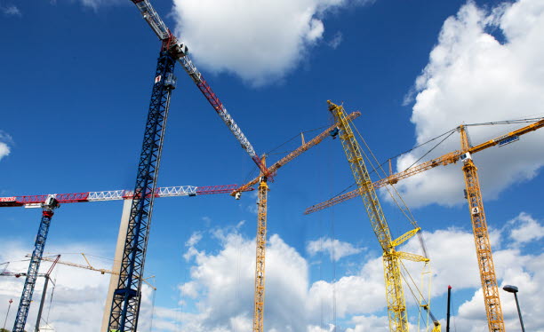 Byggkranar mot en blå himmel med små moln. Foto: Hans Ekestang