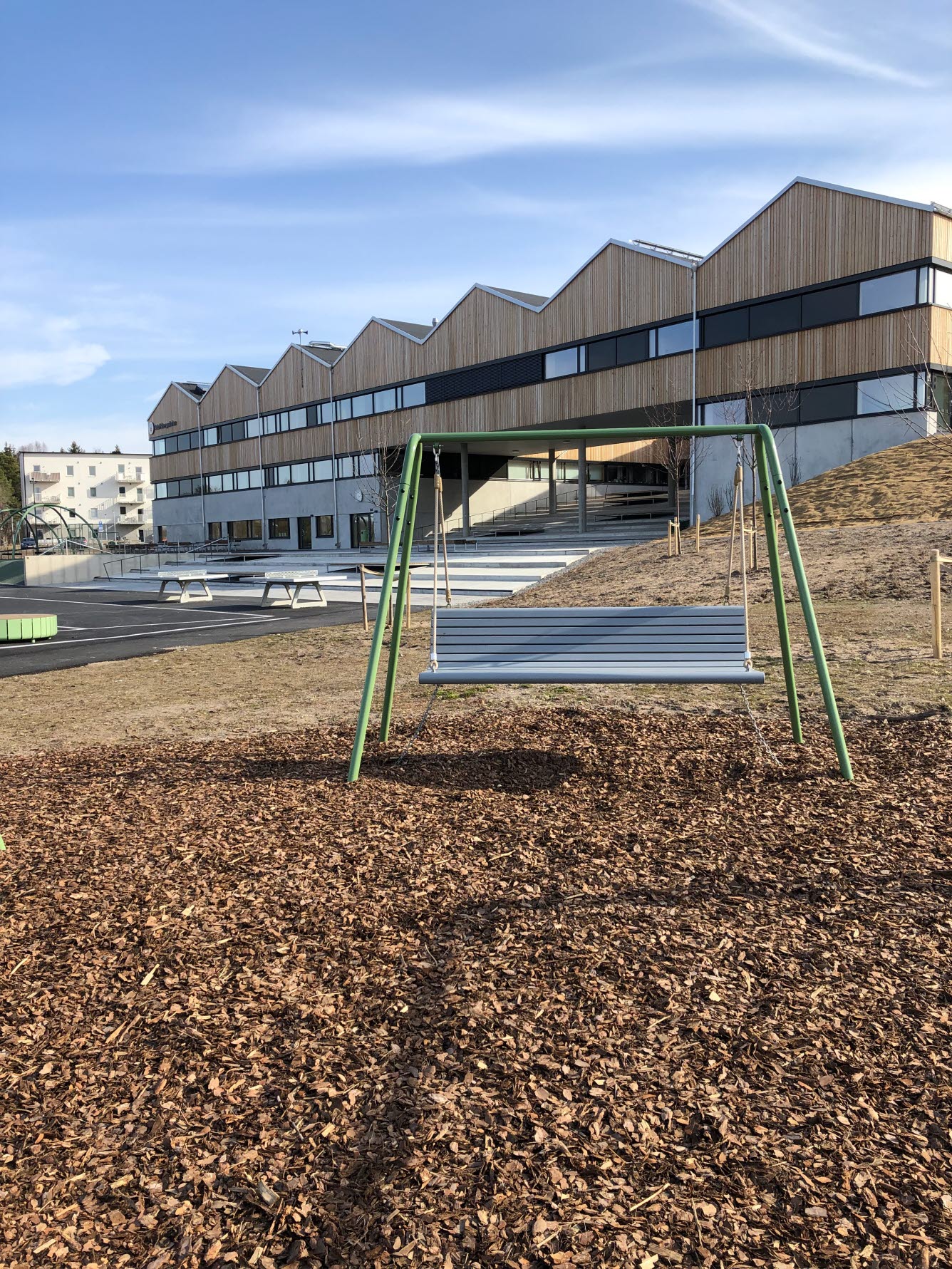 Bänken står i en backe framför skolbyggnaden.