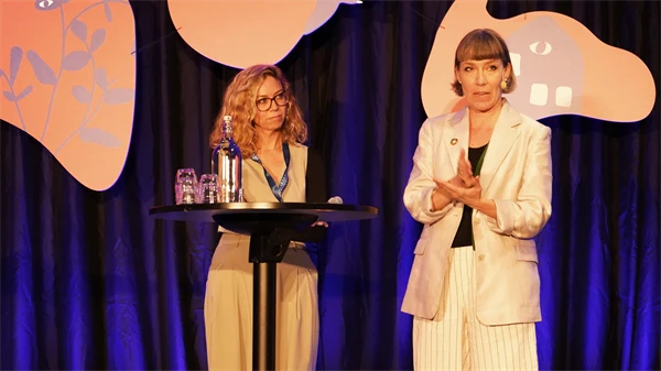 Foto av två kvinnor i ett samtal på konferensens scen.
