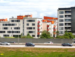 Bilar som kör på väg framför bostadshus. Foto: Hans Ekestang