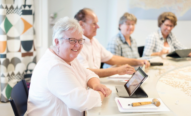 Persoer som sitter runt ett bord. Foto: Peter Kroon