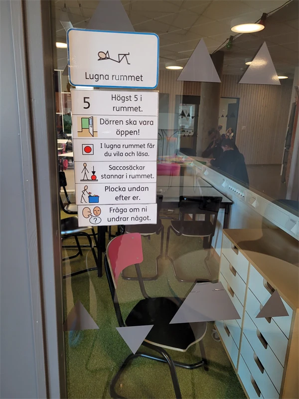 Foto på en glasvägg med en skylt som informerar om vilka regler som gäller i Lugna rummet.