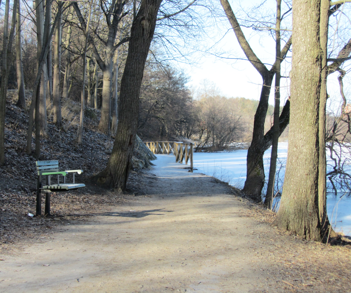 Bänk och räcke vid sjön i Trekantsparken, Liljeholmen.
