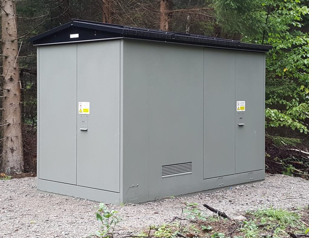 Foto på en mindre transformatorstation i skogen.