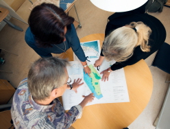 Tre personer tittar på en detaljplan