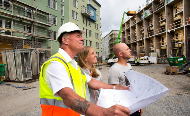 Ett par inspekterar bygge tillsammans med byggherre.