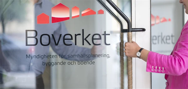 Kvinna öppnar glasdörr med Boverkets logotype på.