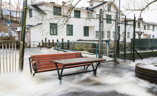 Regn som forsar vid utemiljö med bänk och bord.
